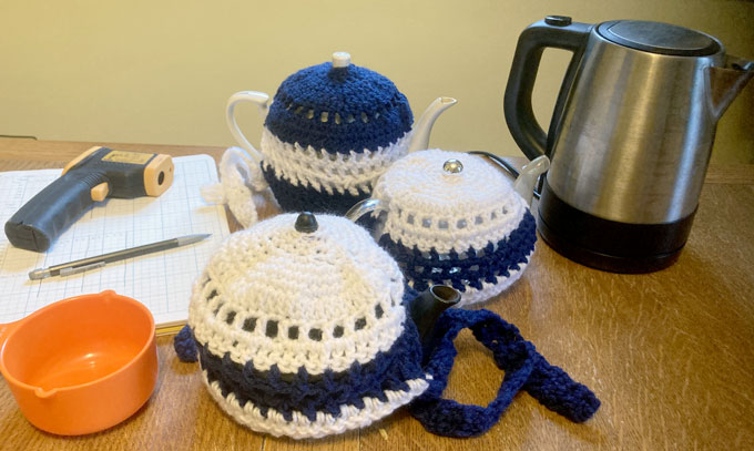 a set of three teapots and their cozies