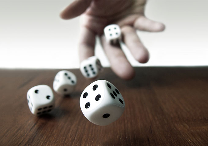a photo of a hand tossing dice onto a table